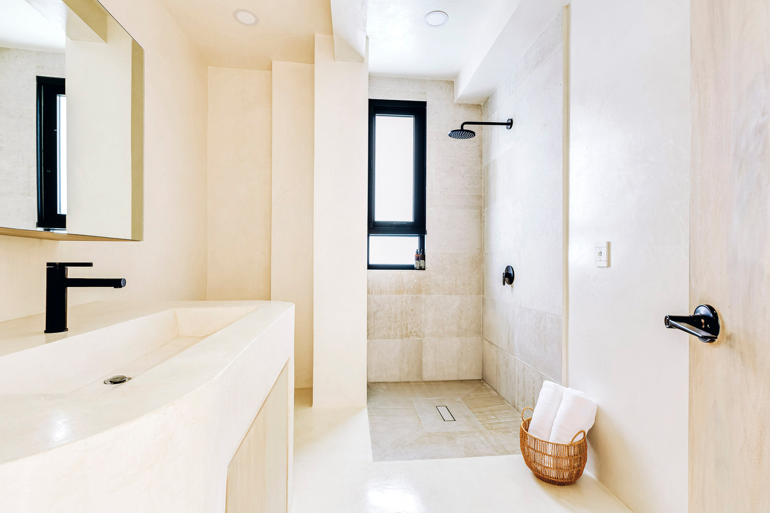 Modern bathroom with white tiles, a shower, and a sink.