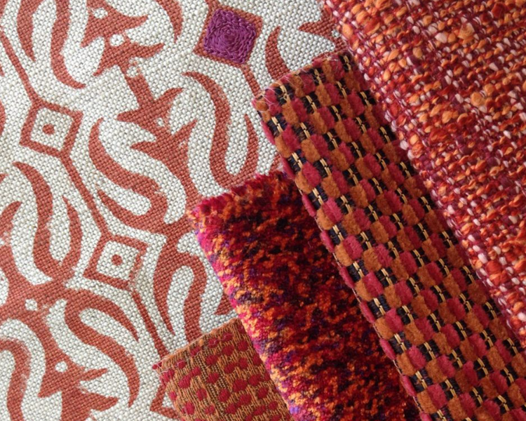 Close-up of textured fabric with intricate patterns in red, white, and brown.